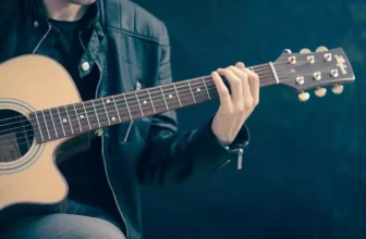 Un guitariste passionné jouant 'Let It Be' sur sa guitare acoustique.